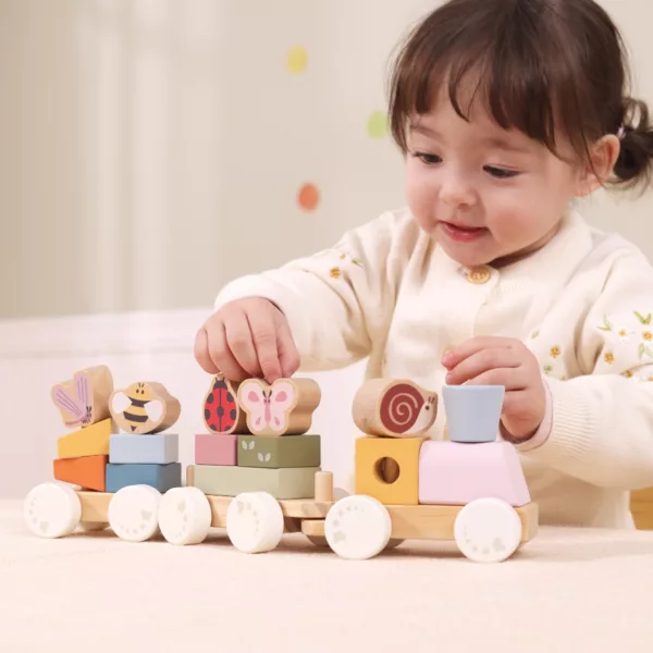 Малко дете играе с дървен влак с животни и форми цветна образователна играчка