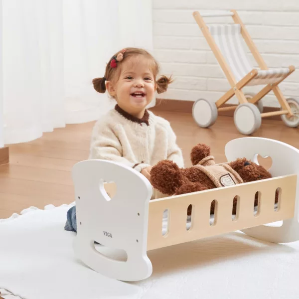 Дървено легло люлка за кукли със сърце, създадено за нежна игра. Подпомага въображението и грижата към другите. Изработено от устойчиво дърво, за деца 36+ месеца.