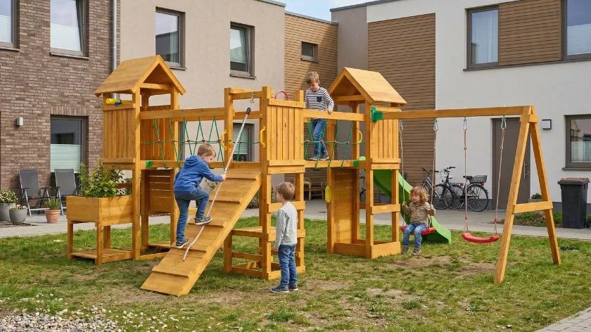 Детска дървена площадка с рампа, катерушка и люлки в модерен двор за деца над 3 години