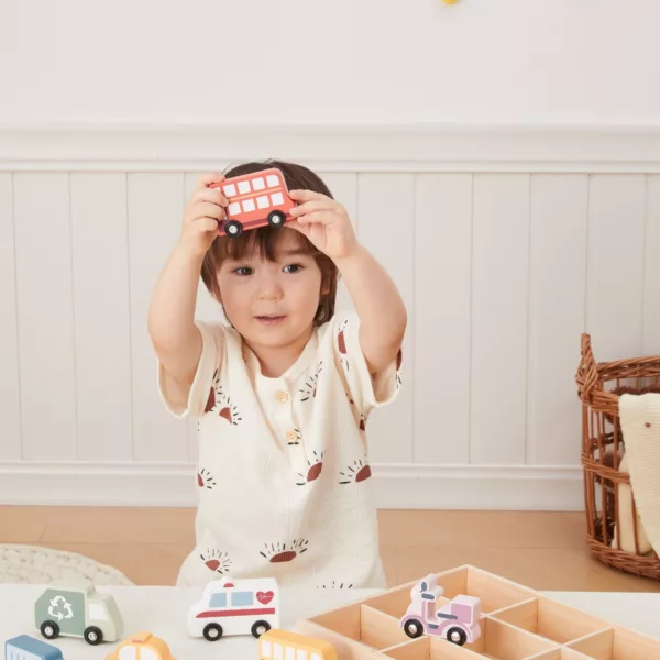 Усмихнато дете държи дървена количка PolarB цветен автобус играчка