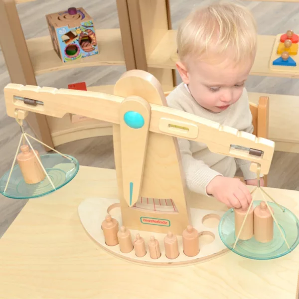 Дете играе с Монтесори дървена везна Masterkidz с тежести за баланс и логическо мислене