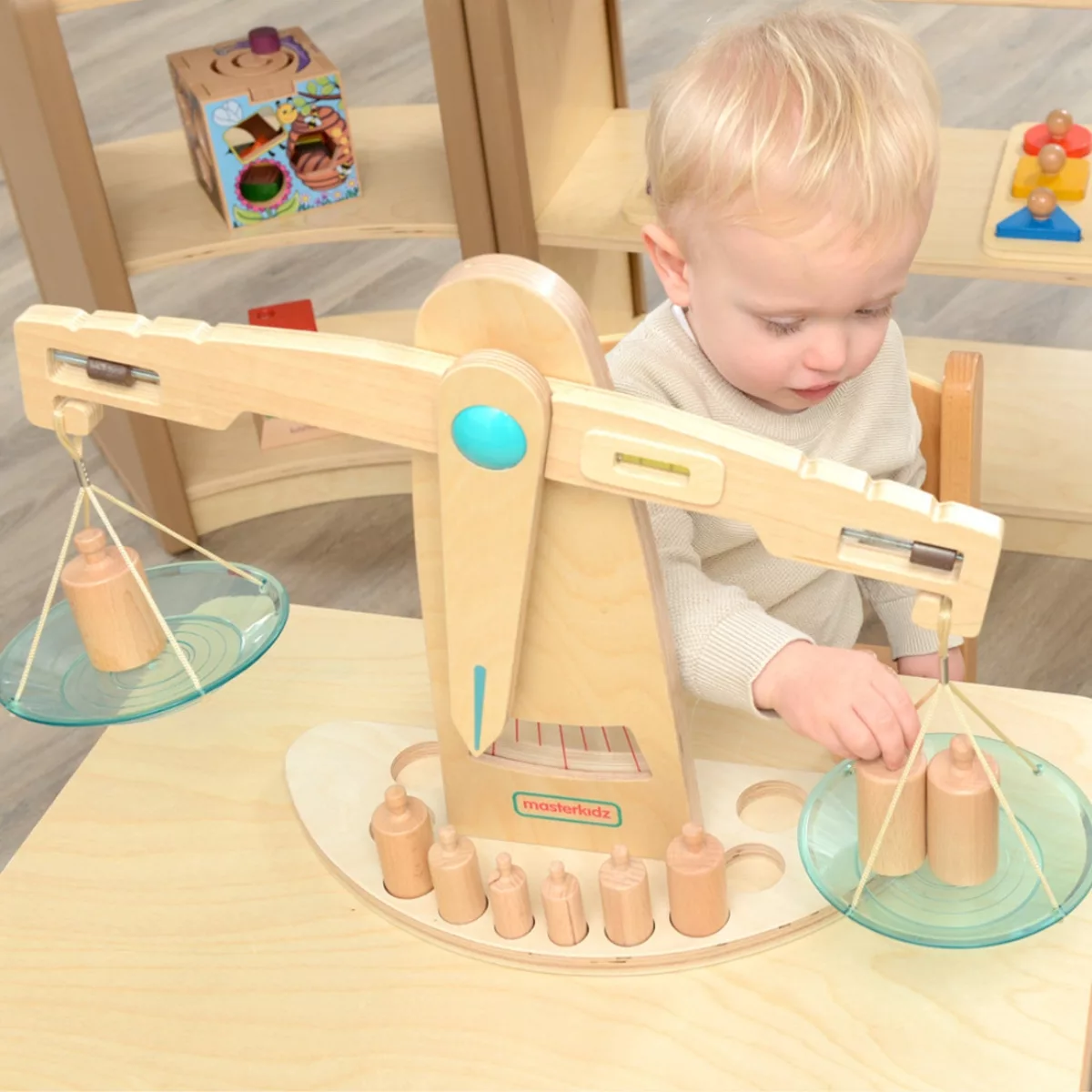 Дете играе с Монтесори дървена везна Masterkidz с тежести за баланс и логическо мислене