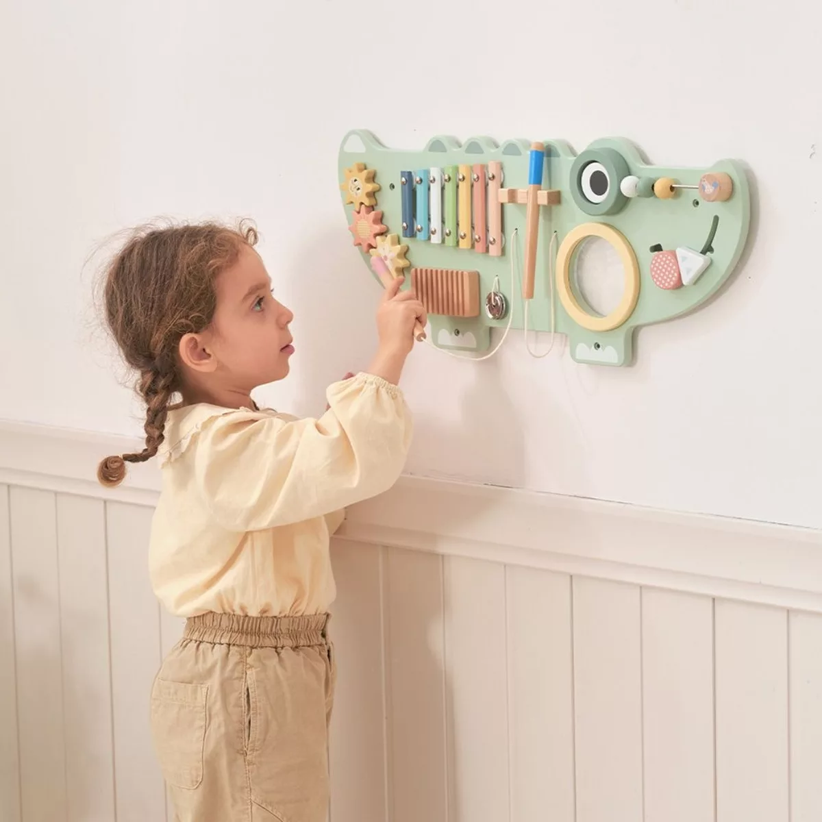 Дете играе с дървена стенна играчка Крокодил Tooky Toy за моторика