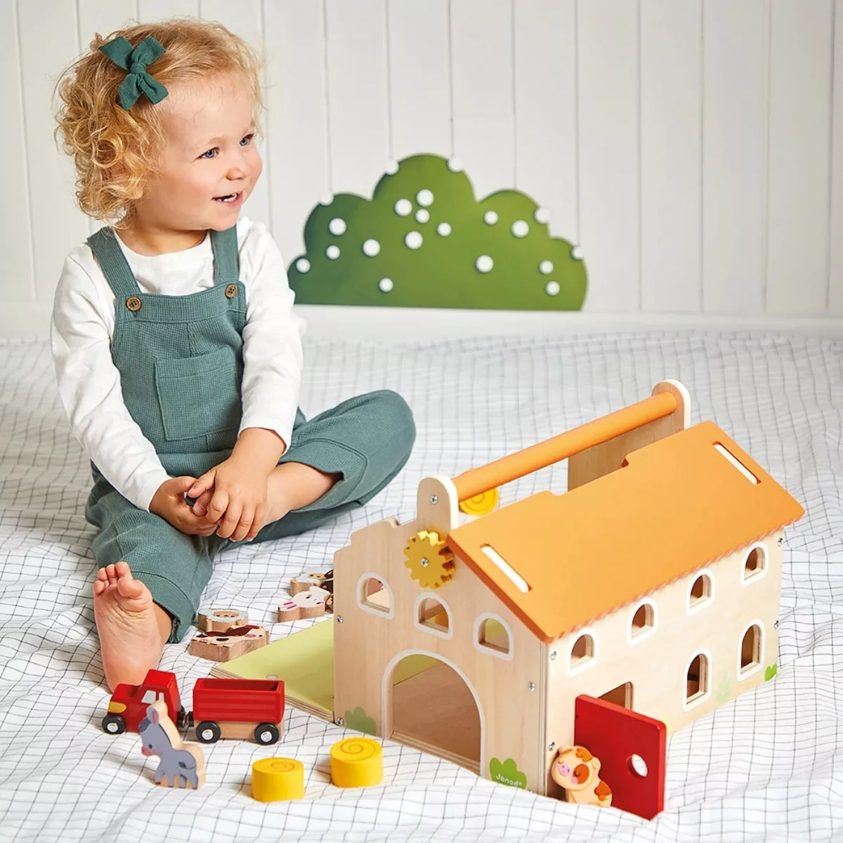 Момиченце играе с дървена ферма Janod, трактор и животни от 2 години