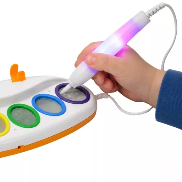 Дете докосва лилавото поле на палитрата със светещата LED четка Jolly